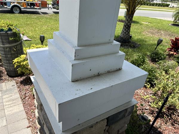 Porch column base before cleaning, white trim spotted with dirt