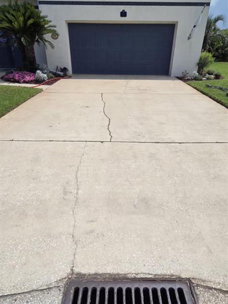 The same concrete driveway after pressure washing, clean and bright, St. Augustine