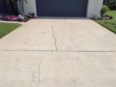 The same concrete driveway after pressure washing, clean and bright