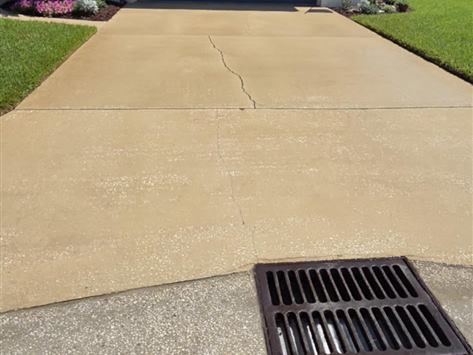 Concrete driveway before cleaning, stained yellow and grey