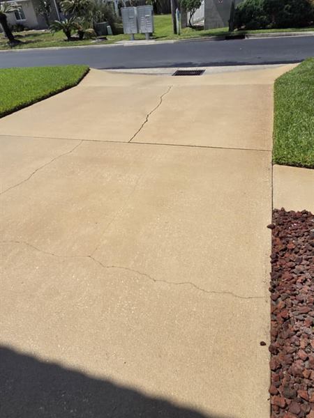 Clean concrete driveway seen from the street, after pressure washing