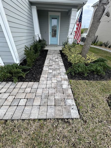 Paver front walkway leading to a front door, freshly cleaned