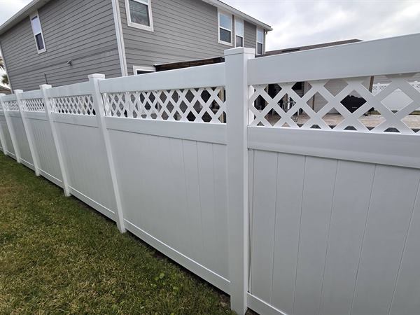 The same lattice-top vinyl fence after cleaning, bright white