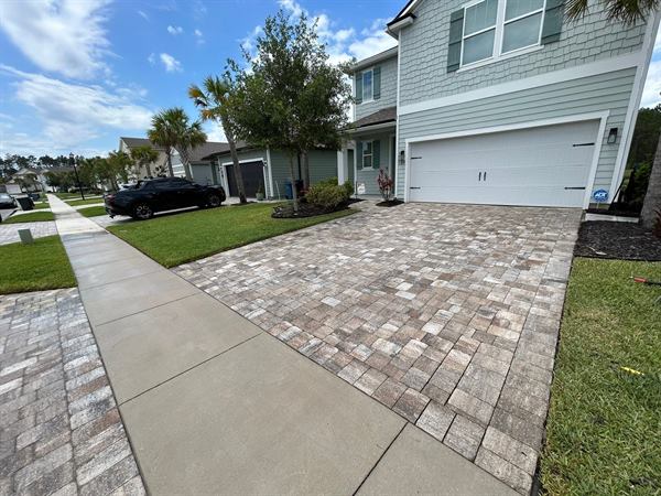 Paver driveway and walkway in front of a two-story home after cleaning, St. Augustine