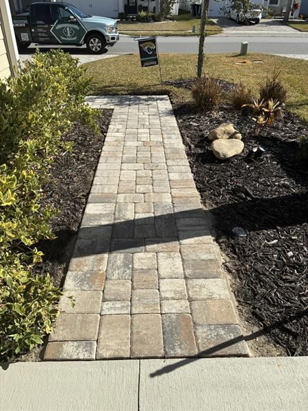 Paver walkway through a mulched garden bed, freshly cleaned