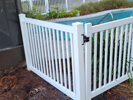 White vinyl pool fence around a backyard pool after cleaning