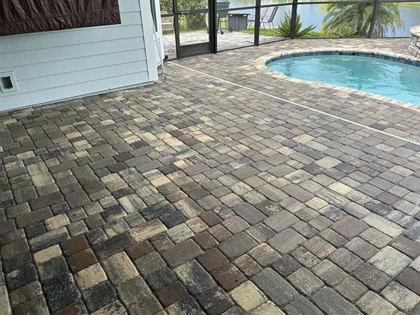 Clean paver pool deck beside a swimming pool