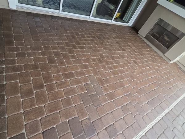 Pool deck pavers after pressure washing, rich brown again