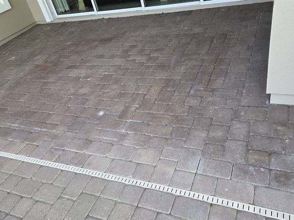 Screened pool deck pavers before cleaning, dull and grey