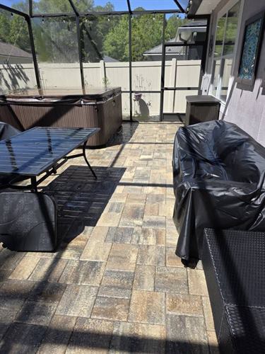 Screened lanai with a hot tub and clean paver floor
